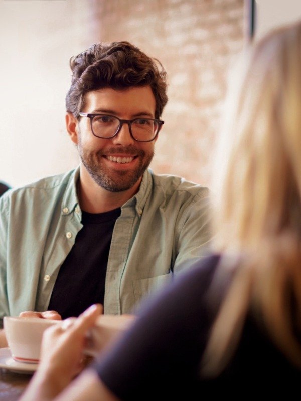 a smiling man and a blonde woman have a coffee date