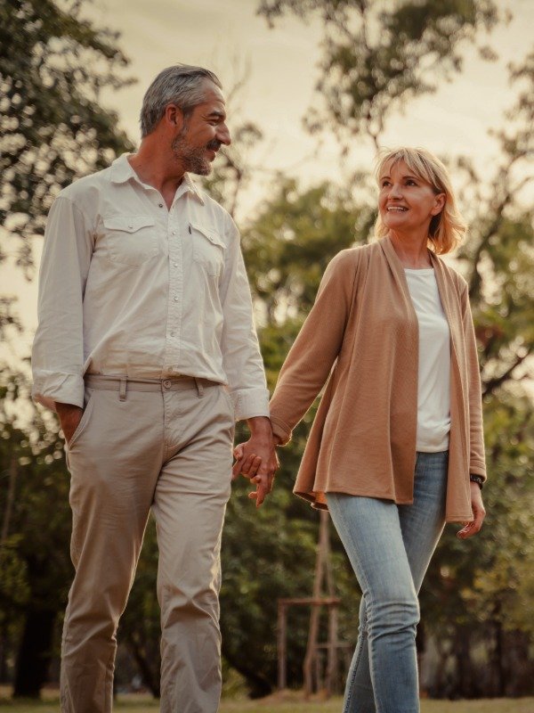 is-this-right-for-you a happy and mature couple walk outdoors while holding hands